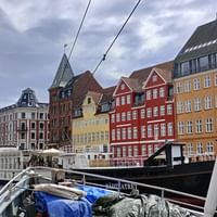 Historischer Nyhavn-Hafen mit bunten Häusern und Segelschiffen. Blick vom Bootsdeck auf traditionelle dänische Architektur entlang der Uferpromenade.