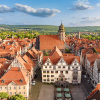 Aerial view of Hann. Münden's historic town hall with Renaissance facade and surrounding half-timbered buildings with red tile roofs.