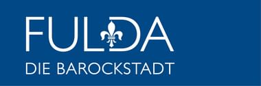 Weißes Logo auf blauem Hintergrund mit 'FULDA', einer Lilie und Untertitel 'DIE BAROCKSTADT'.