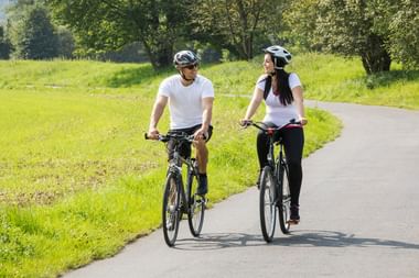 Cyclists on Lahn Cycle Route near Marburg Two cyclists with helmets riding bikes on paved path through green countryside near Marburg on the Lahn Cycle Route.