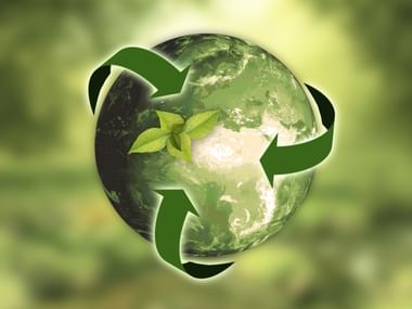 Grüne Erdkugel umgeben von drei grünen Recyclingpfeilen mit kleinen Blättern, Symbol für CO2-Nachhaltigkeit und Umweltschutz.