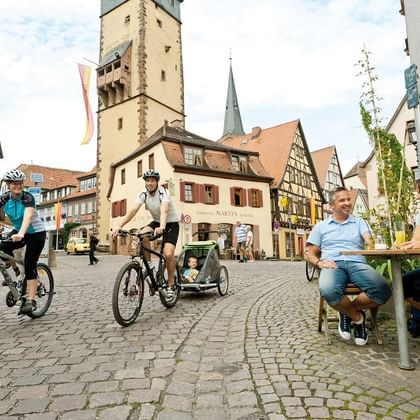 Lohr Radler mit Kind in Lohrer Altstadt mit Blick auf den Bayersturm