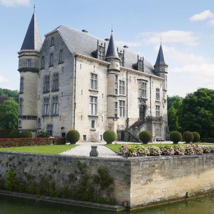 Schloss Schaloen in Valkenburg, ein weißes Renaissance-Schloss aus Stein mit mehreren Türmen, umgeben von gepflegten Gärten.