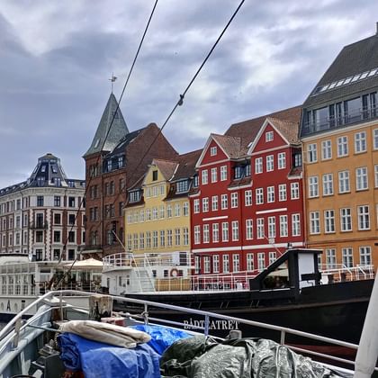 Historischer Nyhavn-Hafen mit bunten Häusern und Segelschiffen. Blick vom Bootsdeck auf traditionelle dänische Architektur entlang der Uferpromenade.
