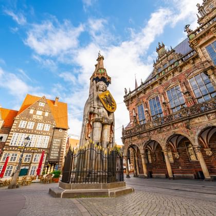 Bremen Roland statue at historic market square The Bremen Roland statue stands in the center of the historic market square, surrounded by colorful medieval buildings and the ornate town hall.