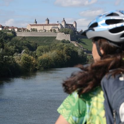 Würzburg Radlerin vor dem main und der Festung Marienburg